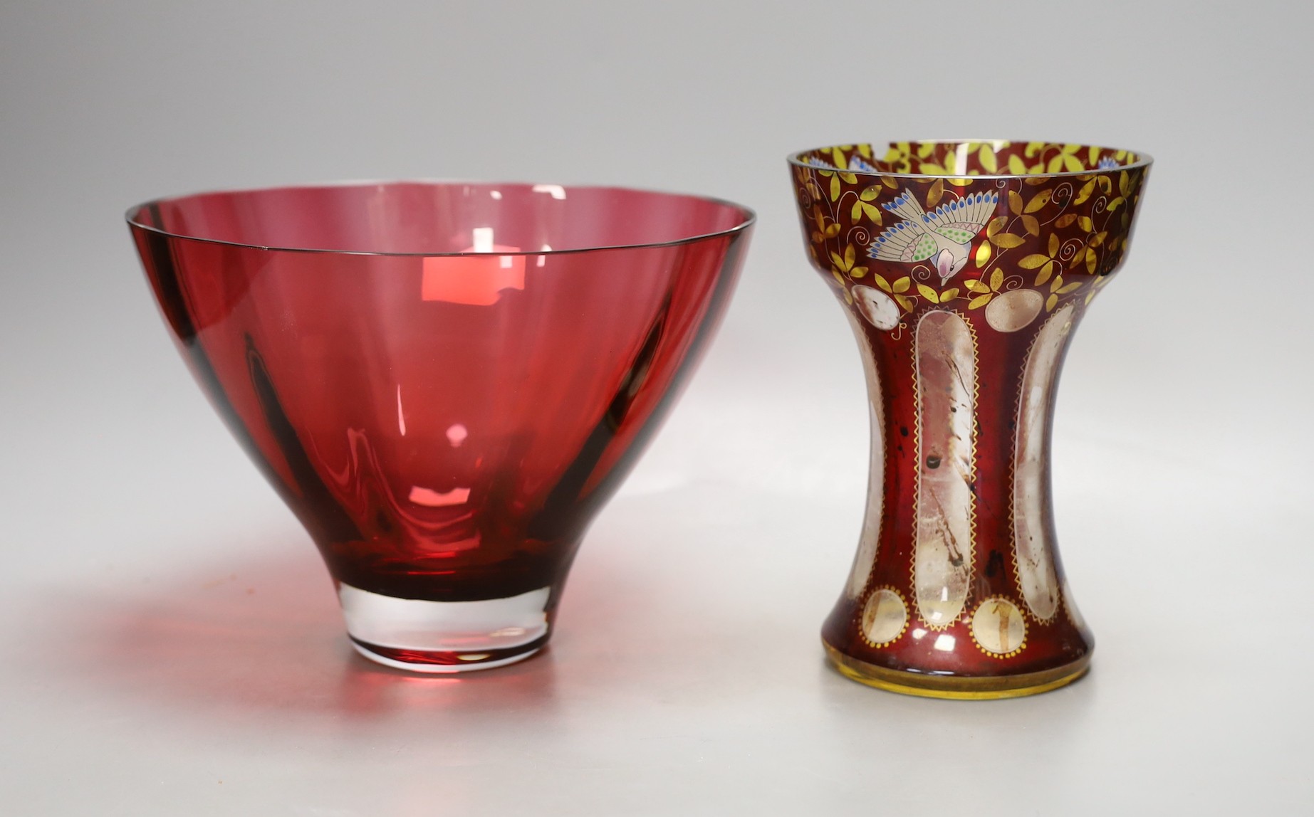 An American? enamelled glass vase and a ruby glass bowl, bowl 23.5 cms diameter.